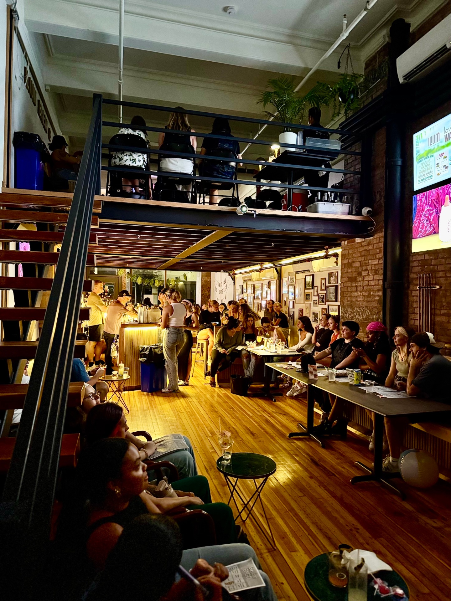 Packed house at Ilium Bar with mezzanine seating and live event