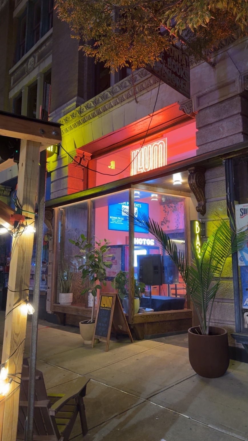 Ilium Bar & Brewing storefront at night with neon signage